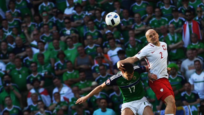 Northern Ireland's Paddy McNair, left, vies for the ball with Poland's Michal Pazdan.