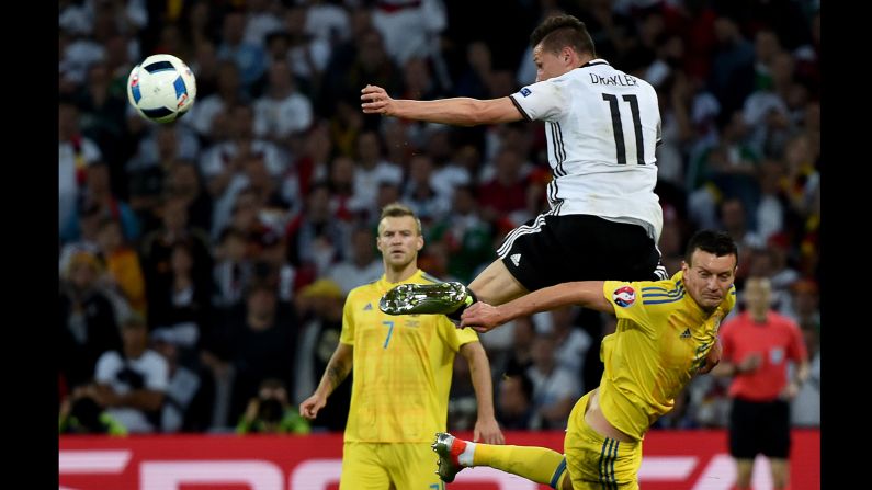 Draxler heads the ball over Artem Fedetskiy.