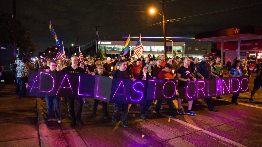 Mourners hold an LED sign as they march during a vigil in Dallas on Sunday, June 12.