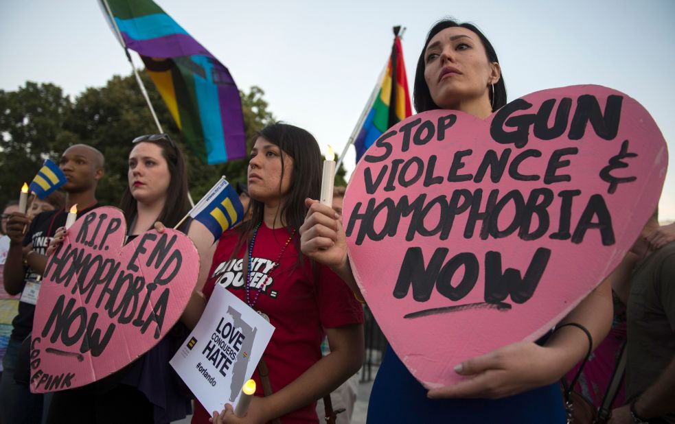 Mourners hold up signs during a vigil in Washington on June 12.