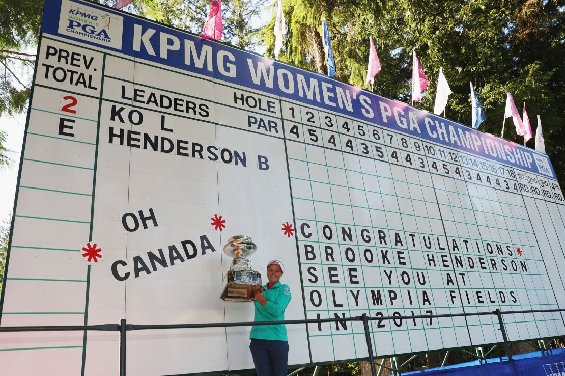 Henderson poses by the scoreboard after claiming victory in a playoff.