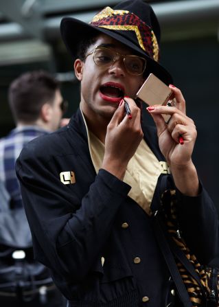 A show attendee fixes his lipstick after the Lou Dalton show.