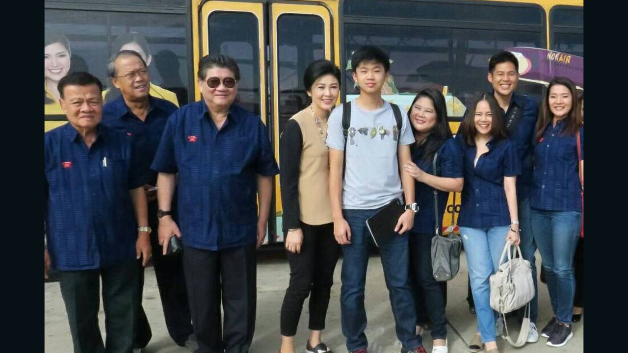 Thailand's former PM Yingluck Shinawatra (center) poses for a photo with her son and entourage during a trip to Phrae province on Sunday June 12, 2016. 