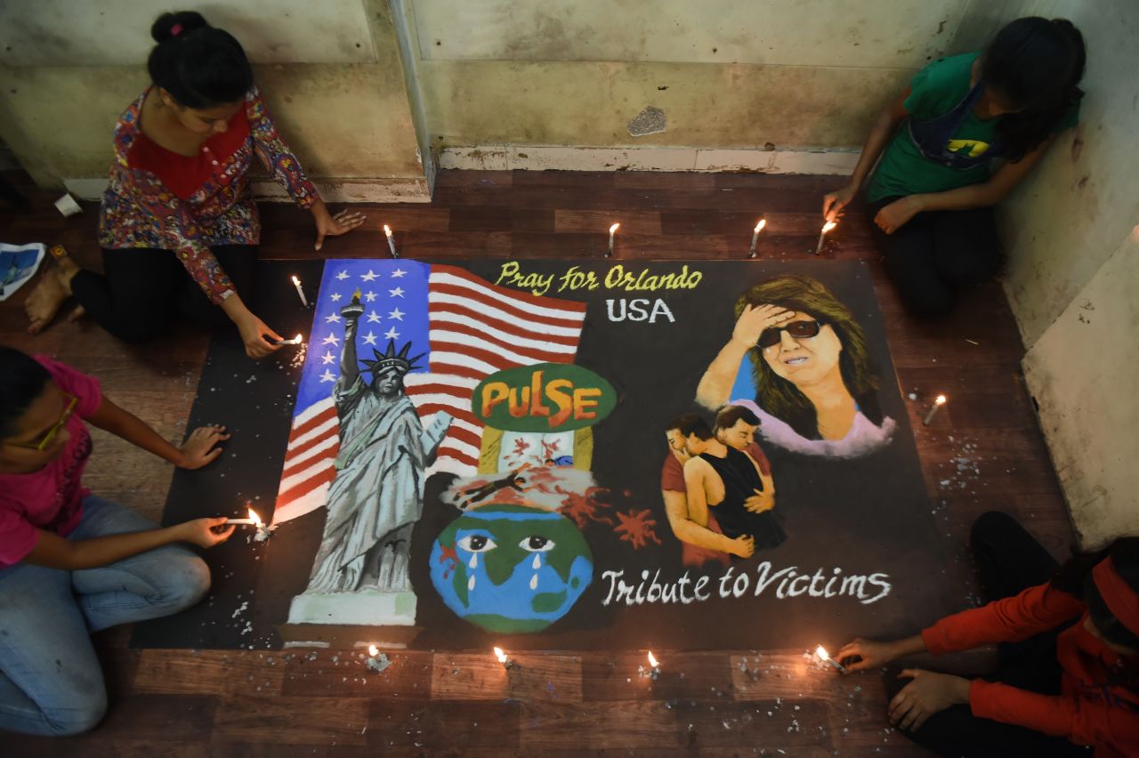 Students in Mumbai, India, light candles near a rangoli, an Indian form of art created on the ground, on June 13.
