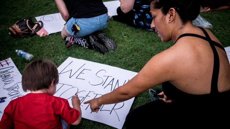 Attendees make signs with messages like "#OrlandoStrong" and "We Stand Together."