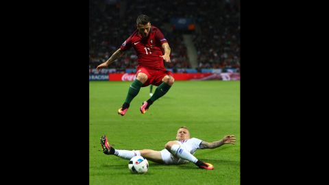 Vieirinha jumps over a tackle from Iceland's Ari Skulason.