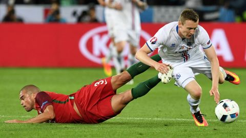 Portuguese defender Pepe collides with Jon Dadi Bodvarsson.