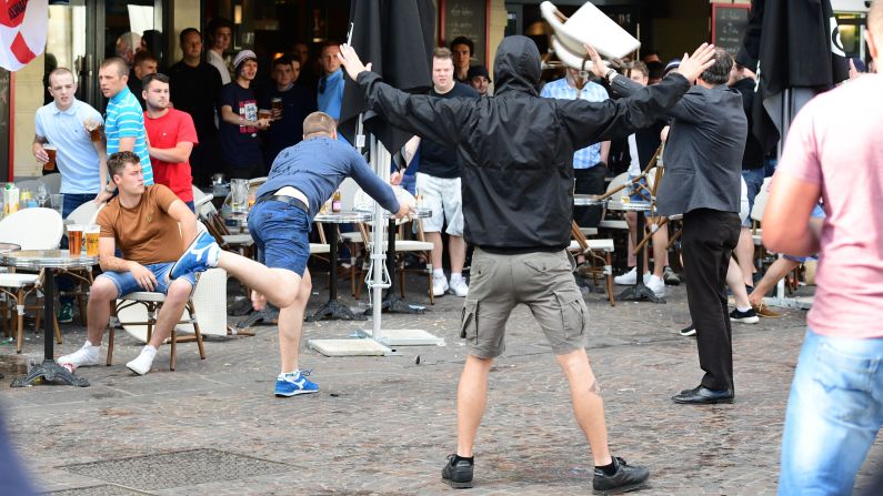 A Russia fan lobs a chair towards England fans sitting in a cafe in Lille, France, on Tuesday. Many England fans going to Lens have to travel through nearby Lille, where Russia is playing Slovakia on Wednesday.