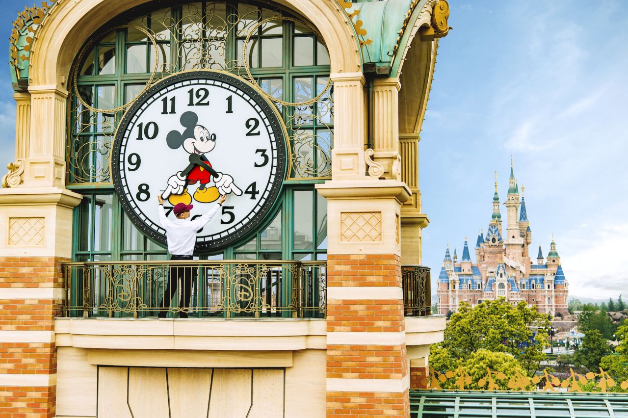 A Shanghai Disneyland cast member sets the theme park's Mickey Avenue clock prior to the official June 16 opening. 