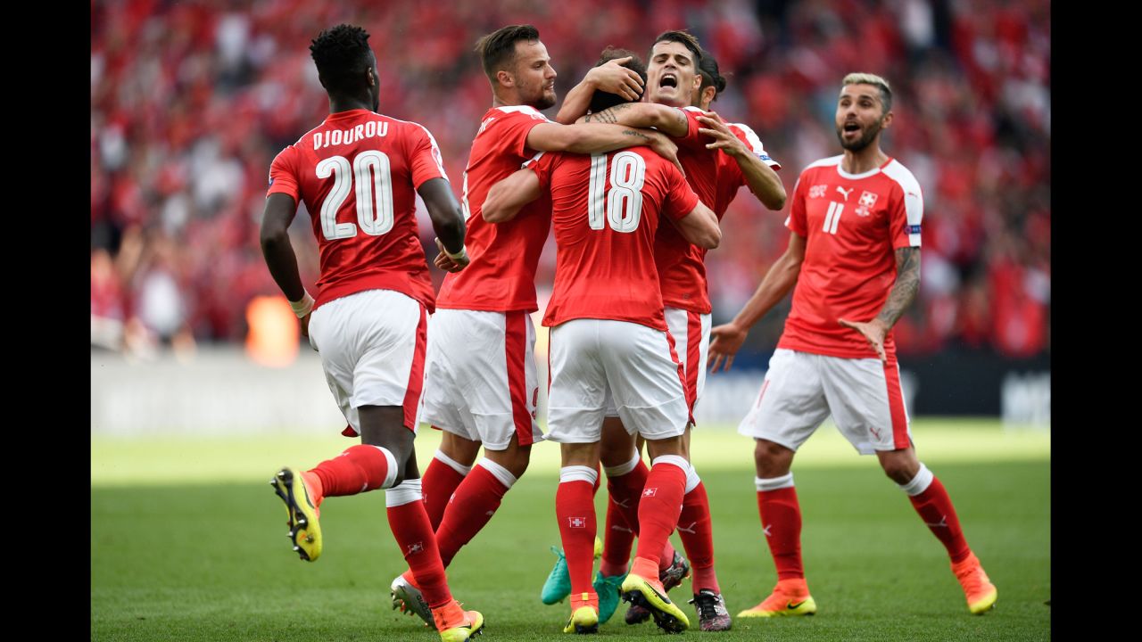 Switzerland players celebrate after Admir Mehmedi (No. 18) scored a goal to tie Romania in Paris. The match ended 1-1.