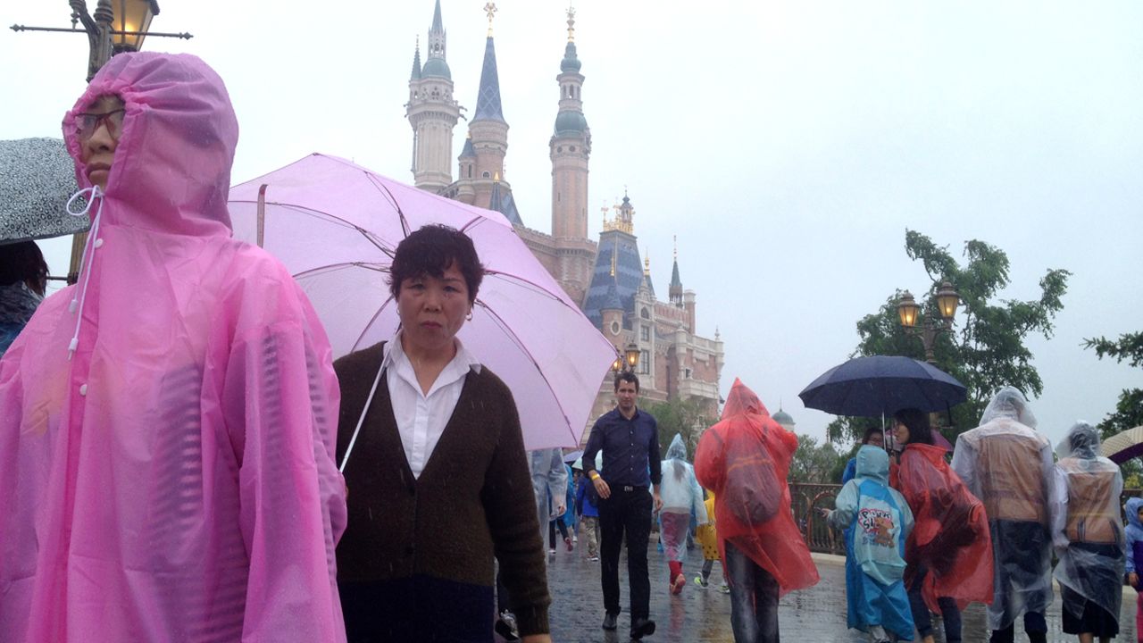 Theme Park Guy Stefan Zwanzger (behind the lady with the pink umbrella) braved the rains to get a preview of Shanghai DIsneyland.