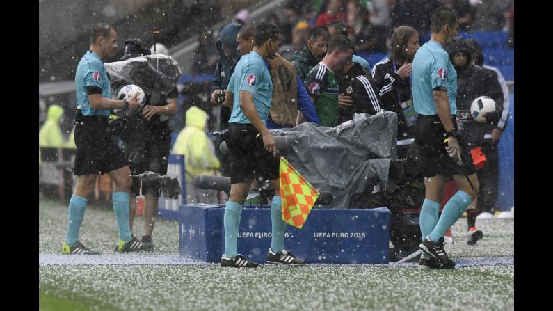 Referees leave the field after the match in Lyon, France, was temporarily stopped because of a hailstorm.