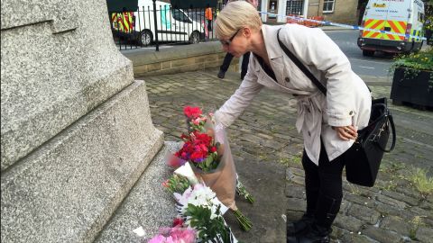 A mourner places flowers at Birstall's Market Square in honor of Jo Cox.