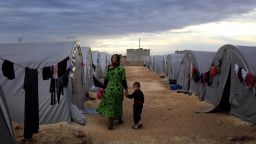 A Kurdish refugee mother and son from the Syrian town of Kobani walk beside their tent in a camp in the southeastern town of Suruc on the Turkish-Syrian border on October 19, 2014 in Sanliurfa, Turkey.  Kurdish fighters in Syrian city of Kobani have pushed back Islamic State militants in a number of locations as U.S. air strikes on ISIS positions continue in and around the city. In the past month more than 200,000 people from Kobani have fled into Turkey. 
