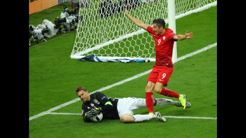 German goalkeeper Manuel Neuer collects the ball near Poland's star forward, Robert Lewandowski.