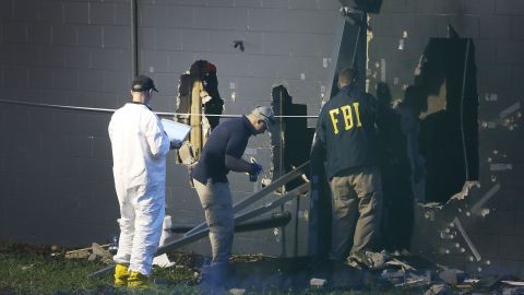 FBI agents investigate near the damaged rear wall of the Pulse Nightclub.