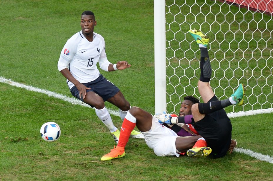 Switzerland's defender Johan Djourou , center, vies on the ground with France's goalkeeper Hugo Lloris, right, beside  midfielder Paul Pogba of France.