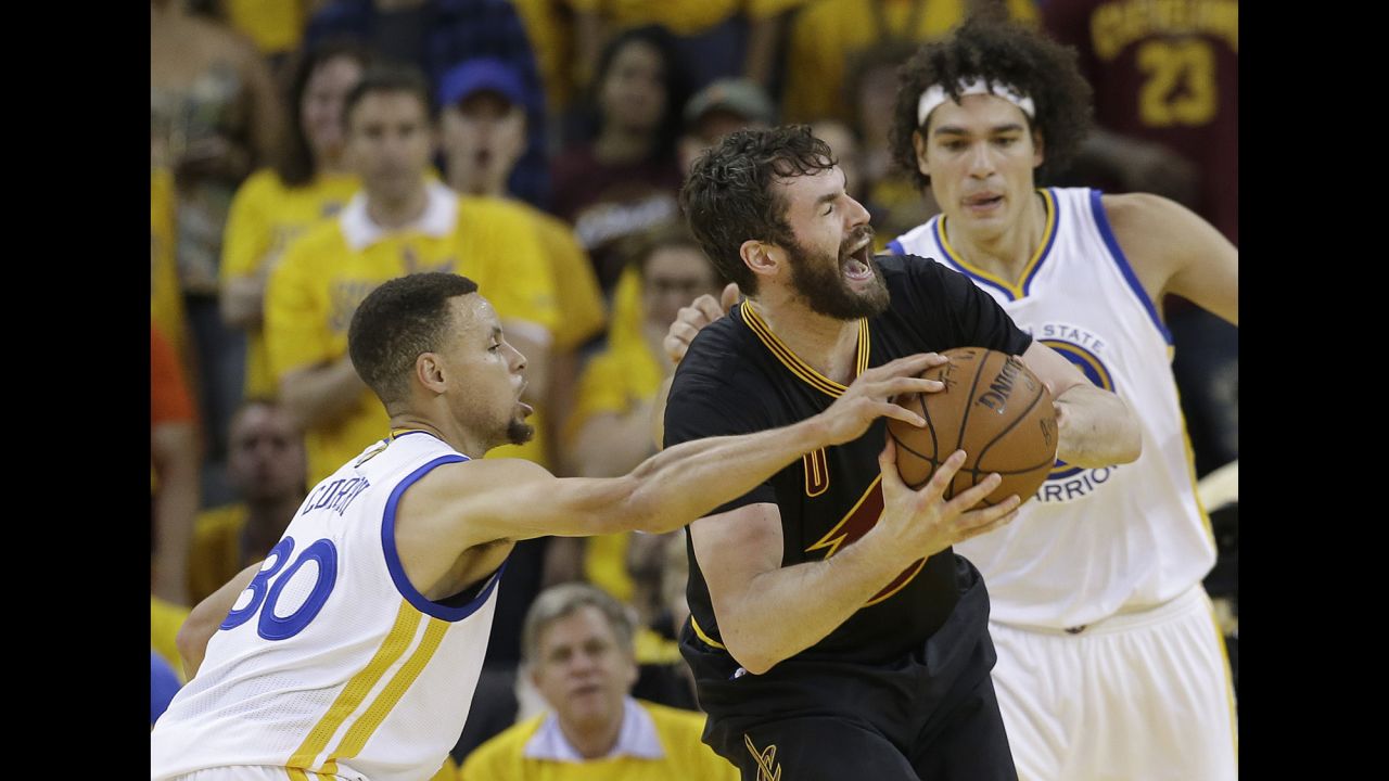 Love is defended by Curry and Anderson Varejao in the first half.