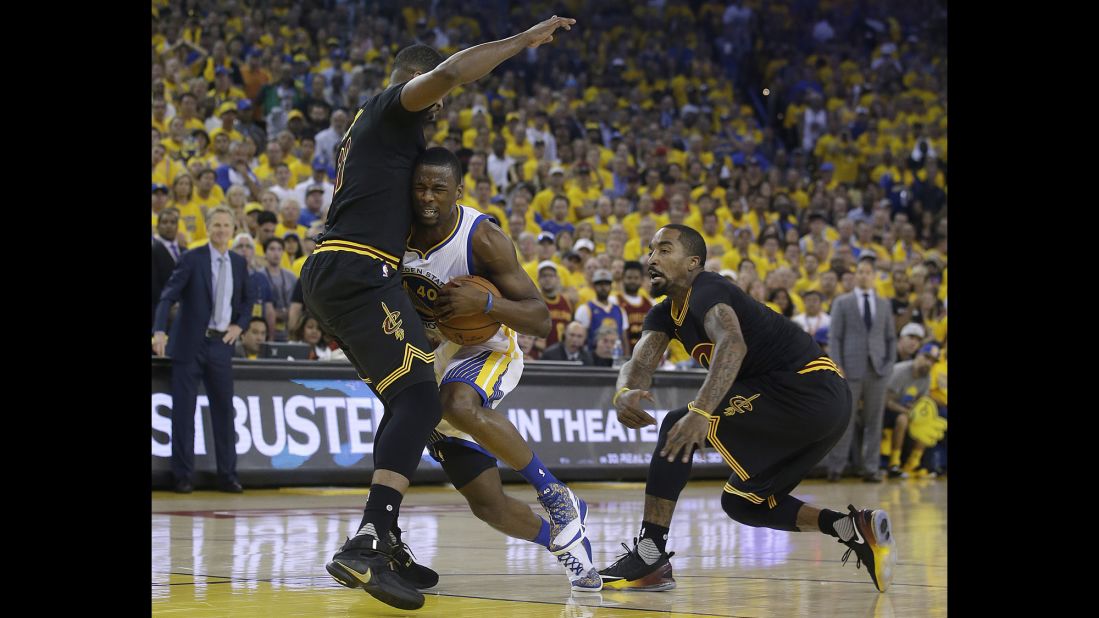 Warriors forward Harrison Barnes tries to drive past Cavaliers center Tristan Thompson, left, and guard J.R. Smith.