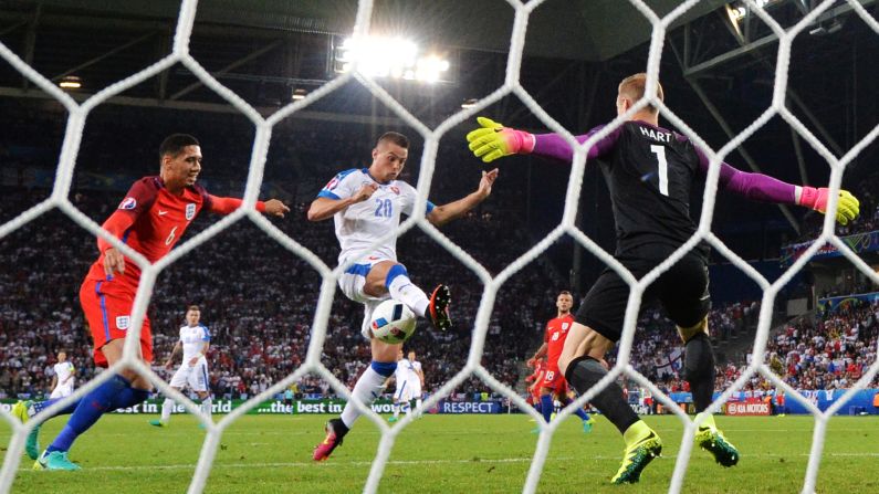 English goalkeeper Joe Hart makes a save on Slovakia's Robert Mak during the two teams' scoreless draw in Saint-Etienne, France. England finished second in the group and is assured of a place in the next round of the tournament. Slovakia finished in third and will have to wait until the end of the group stage to see if they will advance.