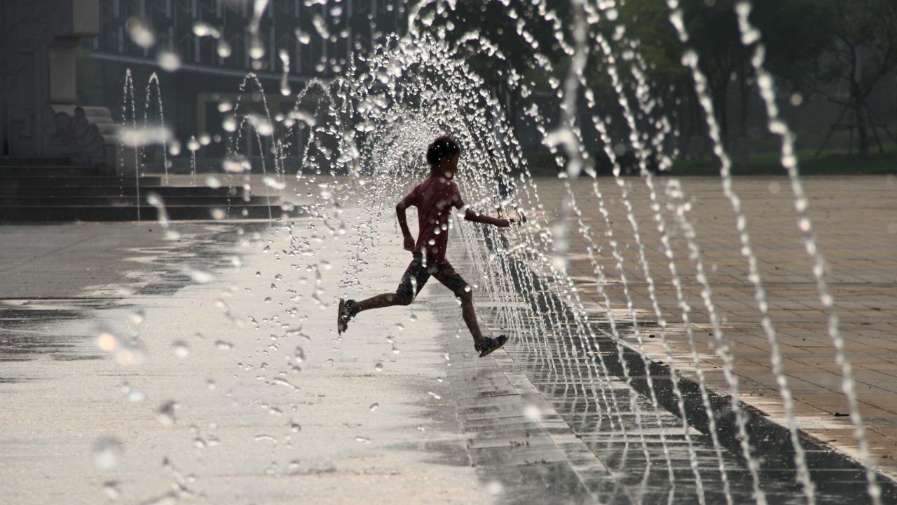 This picture taken on July 26, 2015 shows a child playing in a fountain on a square to cool himself amid a heatwave in Binzhou, eastern China's Shandong province. CHINA OUT AFP PHOTO (Photo credit should read STR/AFP/Getty Images)