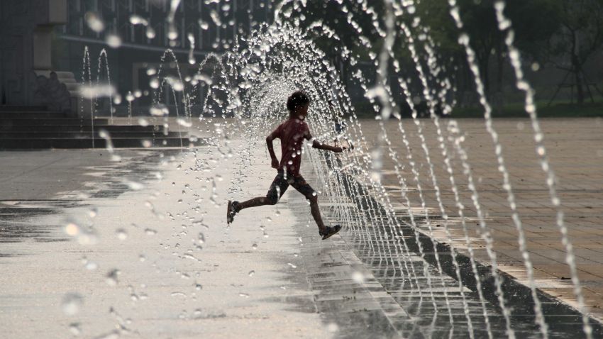 This picture taken on July 26, 2015 shows a child playing in a fountain on a square to cool himself amid a heatwave in Binzhou, eastern China's Shandong province.   CHINA OUT     AFP PHOTO        (Photo credit should read STR/AFP/Getty Images)