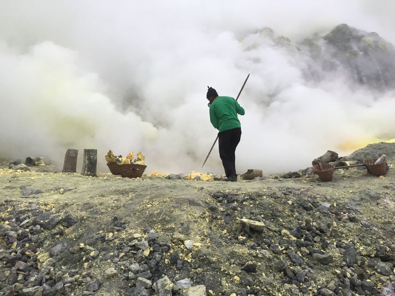 Indonesian men use long metal poles to break off chunks of yellow crust -- sulfur -- from the crater floor. 