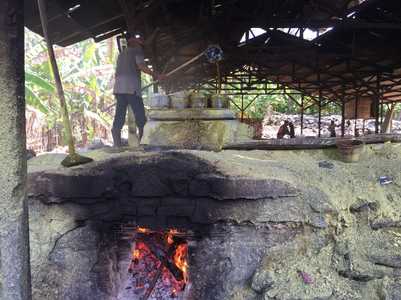Wood-fired ovens heat giant cauldrons where workers melt chunks of sulfur ore down to a liquid.