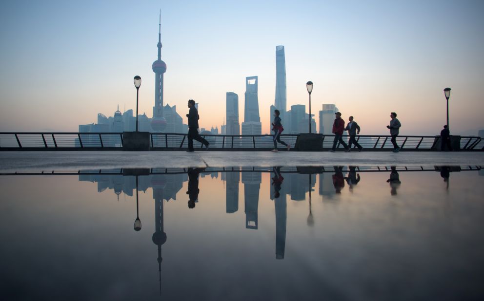 People do their morning exercises in front of the skyline of the Lujiazui Financial District in Pudong, Shanghai, in 2015.