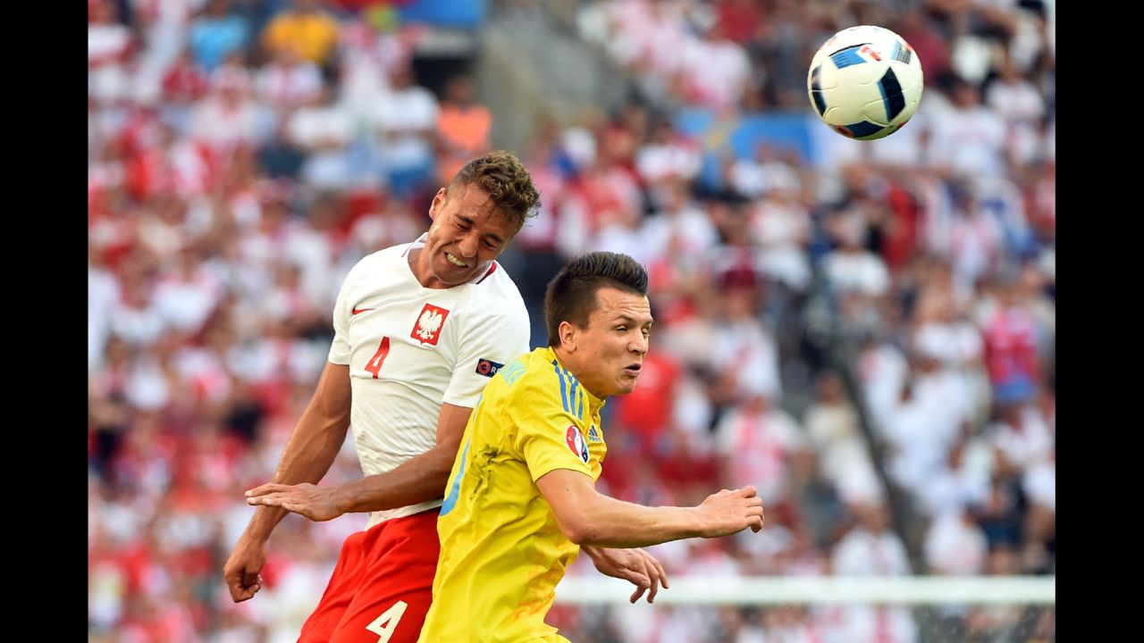 Polish defender Thiago Cionek, left, jumps for the ball with Ukrainian winger Yevhen Konoplyanka.