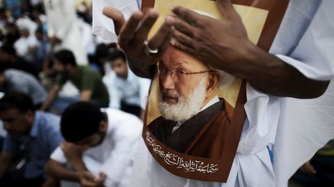 Supporters hold a portrait of Bahraini Shiite cleric Sheikh Isa Qassim at a protest.