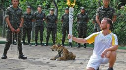 An athlete holds the Olympic Torch by a jaguar --symbol of Amazonia-- during a ceremony in Manaus, northern Brazil, on June 20, 2016.
 
The jaguar, who was named Juma and lived in the local zoo, had to be shot dead by soldiers shortly after the ceremony when he escaped and attacked a veterinarian despite having been hit four times with tranquilizing darts. / AFP PHOTO / Diario do Amazonas / Jair AraujoJAIR ARAUJO/AFP/Getty Images