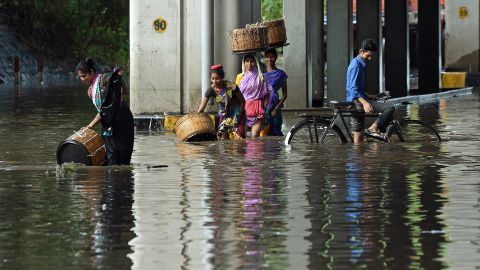 Indians wade through a flooded street Tuesday in Mumbai.