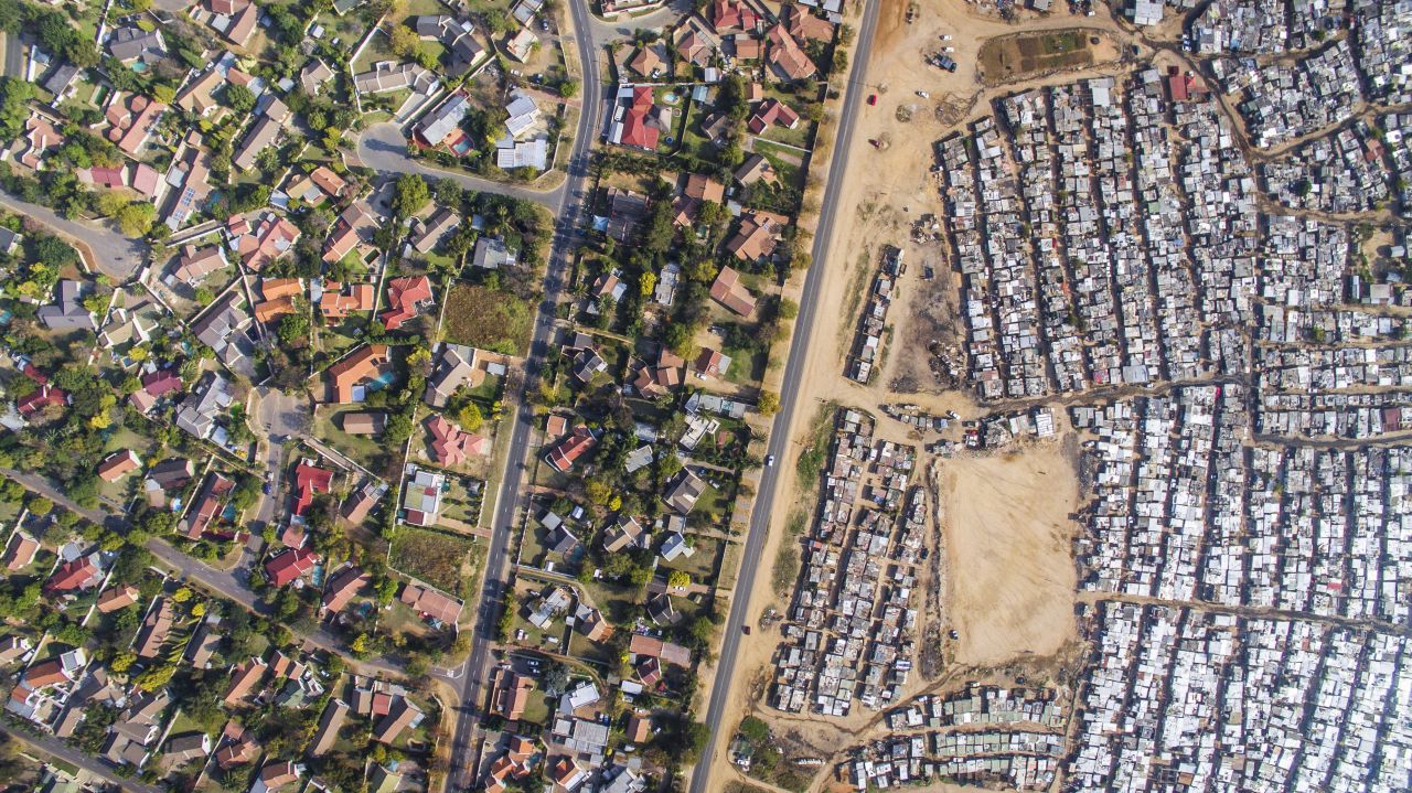 Miller started photographing above Cape Town, though is project has spread to Durban, Johannesburg and Alexandra. In his aerial shots, the viewer can see the disparity between neighboring areas, one a wealthier, gated, white community, the other a poorer, predominantly black urban township. 