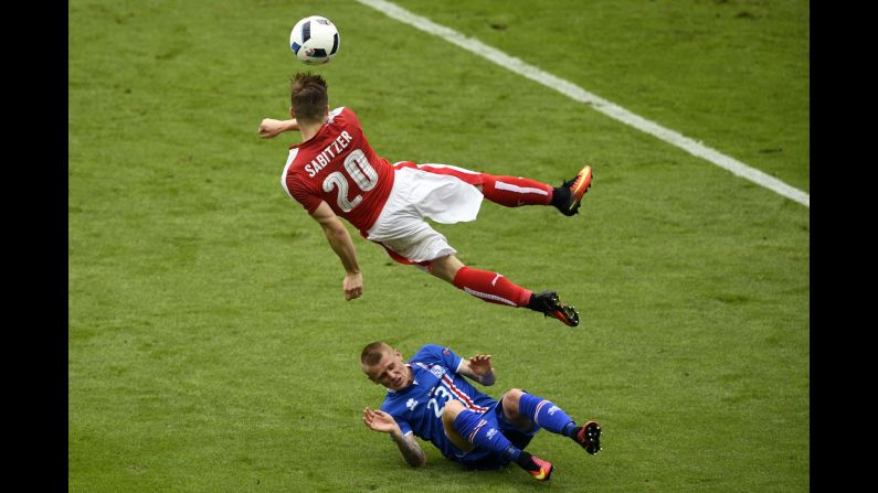 Iceland defender Ari Skulason slides under Austria's Marcel Sabitzer.