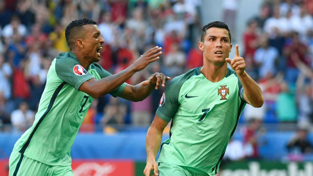 Portugal's forward Cristiano Ronaldo (R) celebrates after scoring a goal  during the Euro 2016 group F football match between Hungary and Portugal at the Parc Olympique Lyonnais stadium in Decines-Charpieu, near Lyon, on June 22, 2016. / AFP / PHILIPPE DESMAZES        (Photo credit should read PHILIPPE DESMAZES/AFP/Getty Images)