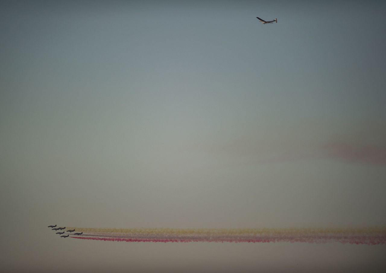 The Spanish Air Force's Patrulla Aguila formation team performs past the sun-powered Solar Impulse 2 aircraft arriving few moments before landing at Sevilla airport on June 23, 2016.