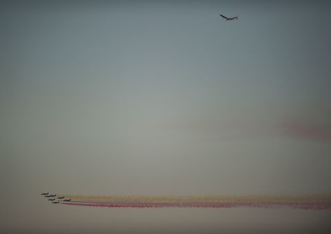 The Spanish Air Force's Patrulla Aguila formation team performs past the sun-powered Solar Impulse 2 aircraft arriving few moments before landing at Sevilla airport on June 23, 2016.