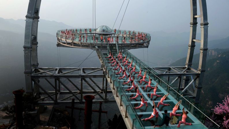 People practice yoga on a sightseeing platform in Beijing on Monday, June 20. 