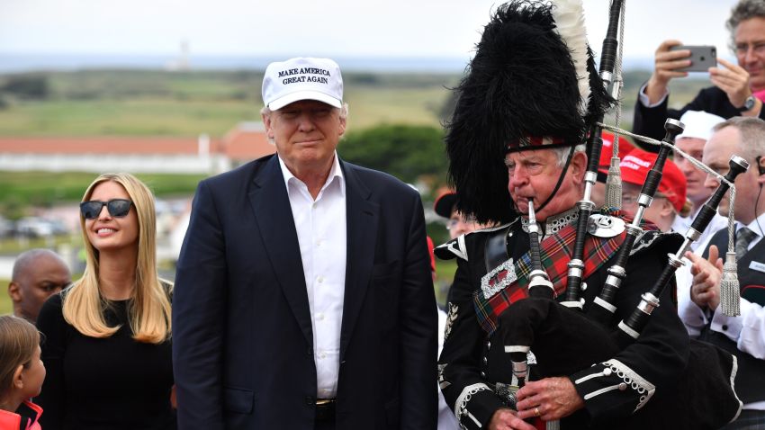 A bagpipe player wears traditional dress next to Presumptive Republican nominee for US president Donald Trump surrounded by his family with his granddaughter Kai Trump and daughter Ivanka Trump (2nd-L) as they arrive to his Trump Turnberry Resort on June 24, 2016 in Ayr, Scotland. Mr Trump arrived to officially open his golf resort which has undergone an eight month refurbishment as part of an investment thought to be worth in the region of two hundred million pounds.