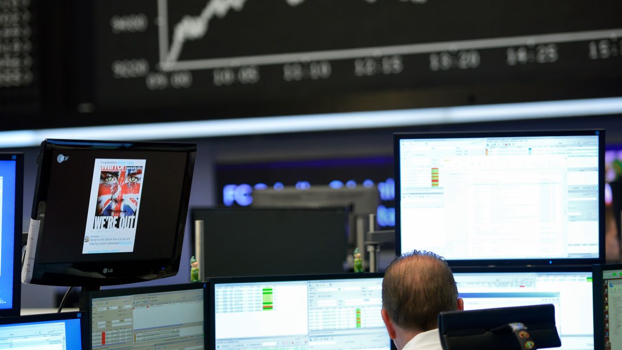 A trader sits at his desk under the day's performance board that shows a dive in the value of the DAX index of companies at the Frankfurt Stock exchange the day after a majority of the British public voted for leaving the European Union on June 24, 2016 in Frankfurt am Main, Germany.