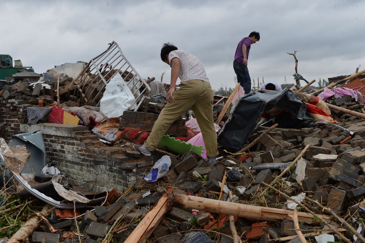 Funing residents search for belongings in the rubble of collapsed houses on June 24.