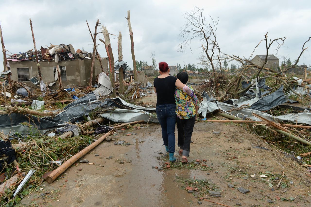 One woman supports another as they pass through the rubble of collapsed houses in Funing on June 24.