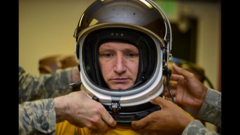 Airmen fasten a helmet onto Air Force Lt. Col. Todd Larsen on Thursday, June 16. Those who pilot U-2 reconnaissance aircraft have to wear pressurized suits to compensate for a lack of atmosphere at ultra-high altitudes.