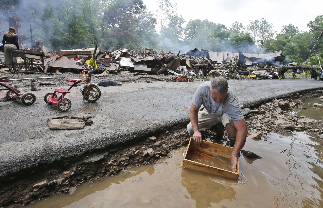 Mark Lester cleans out a box with creek water as he cleans up in White Sulphur Springs on June 24.