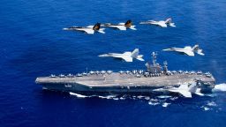 In this handout provided by the U.S. Navy, a combined formation of aircraft from Carrier Air Wing (CVW) 5 and Carrier Air Wing (CVW) 9 pass in formation above the Nimitz-class aircraft carrier USS John C. Stennis (CVN 74). The formation included F/A-18 Hornets from the Black Aces of Strike Fighter Squadron 41, the Diamondbacks of Strike Fighter Squadron 102, the Eagles of Strike Fighter Squadron 115, the Royal Maces of Strike Fighter Squadron 27, the Vigilantes of Strike Fighter Squadron 151, and the Warhawks of Strike Fighter Squadron 97. The Nimitz-class aircraft carriers USS John C. Stennis and USS Ronald Reagan (CVN 76) are conducting dual aircraft carrier strike group operations in the U.S. 7th Fleet area of operations in support of security and stability in the Indo-Asia-Pacific.