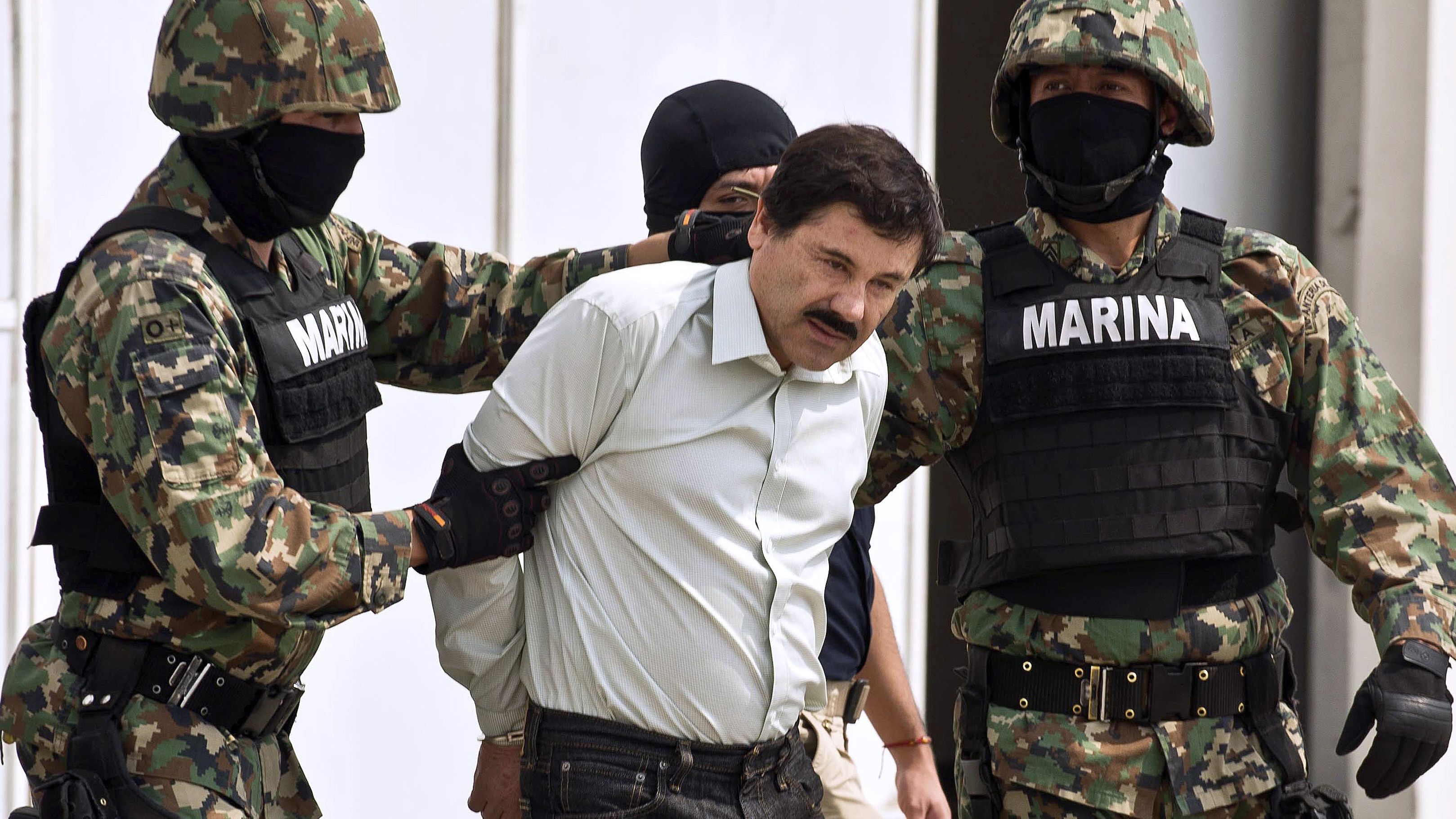 Guzman is escorted by marines as he is presented to the press on February 22, 2014 in Mexico City. 
