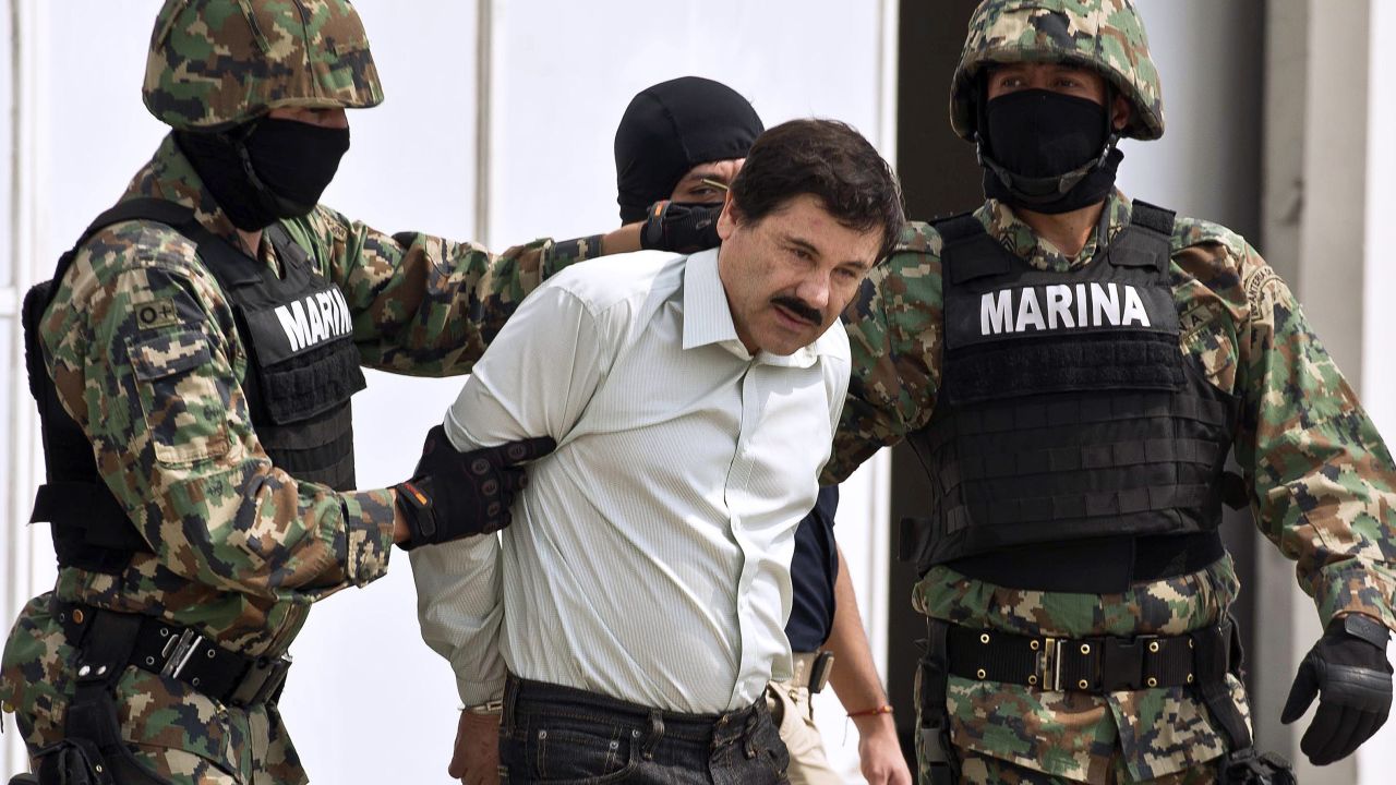 Guzman is escorted by marines as he is presented to the press on February 22, 2014 in Mexico City.