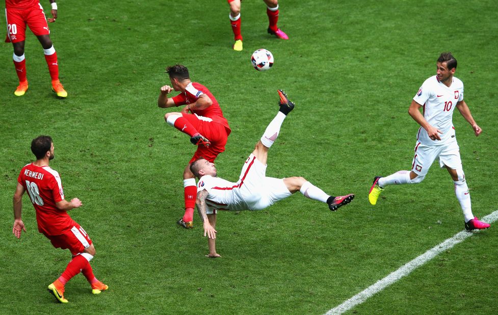 Kamil Grosicki of Poland attempts an overhead kick while Granit Xhaka of Switzerland tries to block.