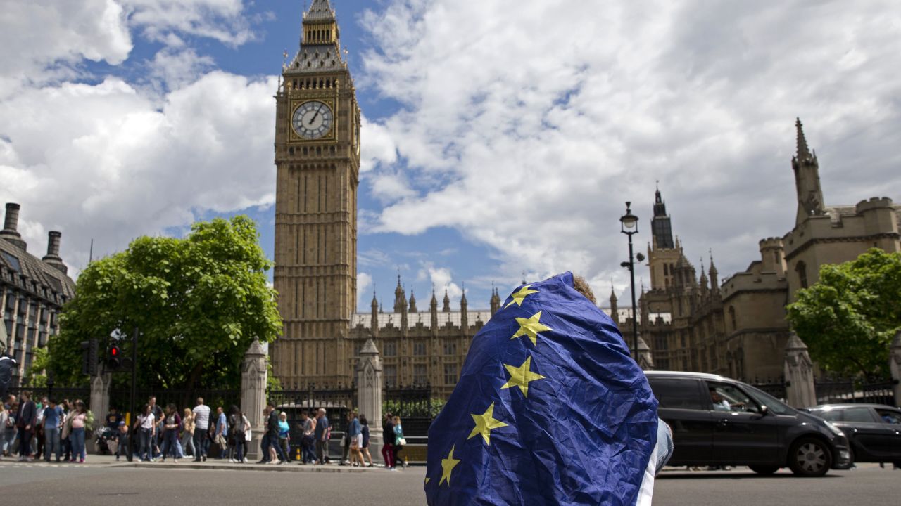 A demonstrator draped in an EU flag sits on floor during a protest against the outcome of the UK's June 23 referendum on the European Union in central London on June 25, 2016.